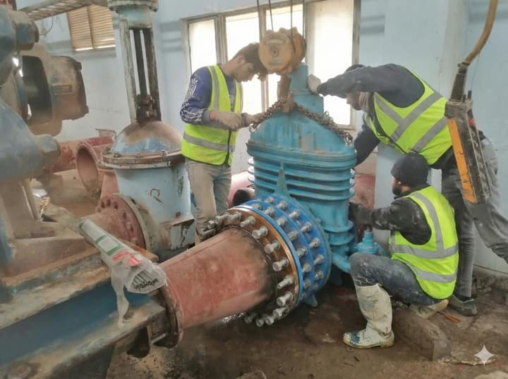 Workers installing pipe in a trench