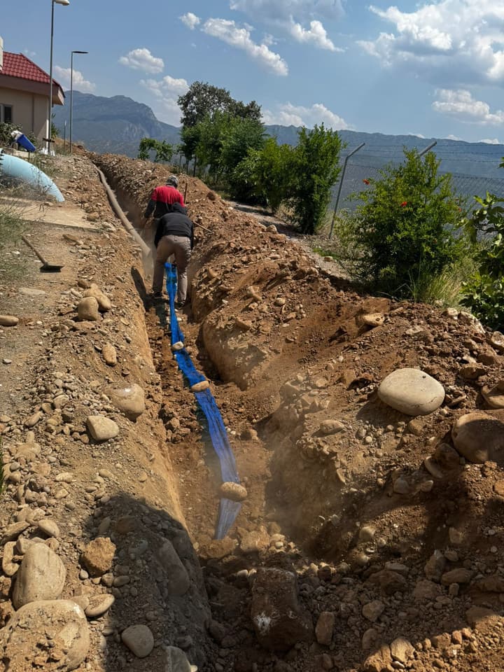 Workers installing pipe in a trench