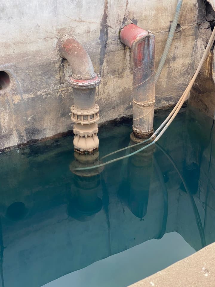 Workers installing pipe in a trench